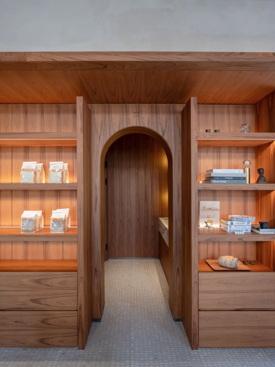 A cozy room with a wooden doorway, books, bottles, and bowls, giving a lived-in feel