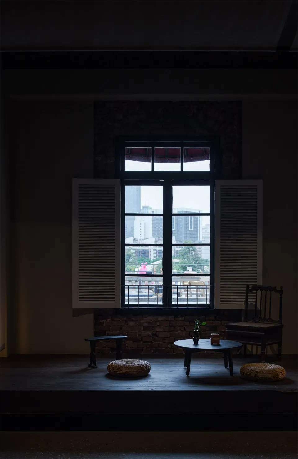 Cozy living space with natural light, a chair, two couches, and a dining table, overlooking a city street
