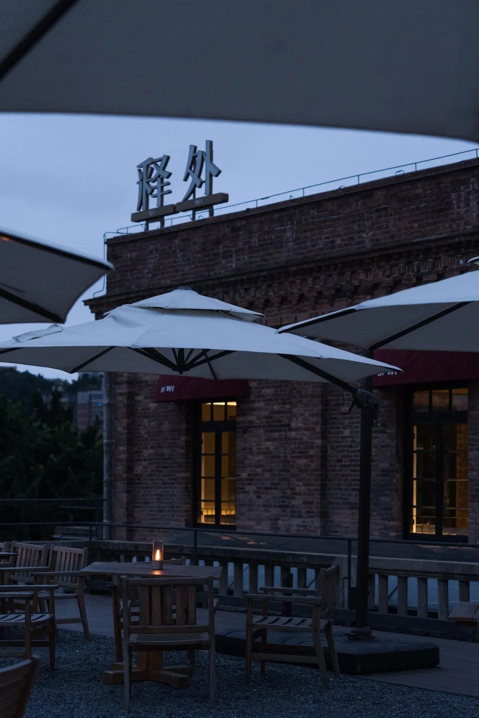 Outdoor dining area with brick facade, umbrellas, and tables and chairs