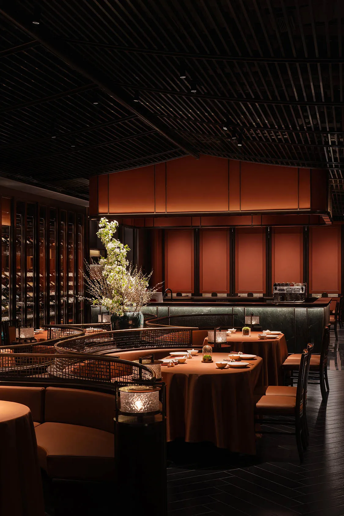 大型用餐區配木皮牆面、多張餐桌椅與酒杯，展現優雅與精緻氛圍