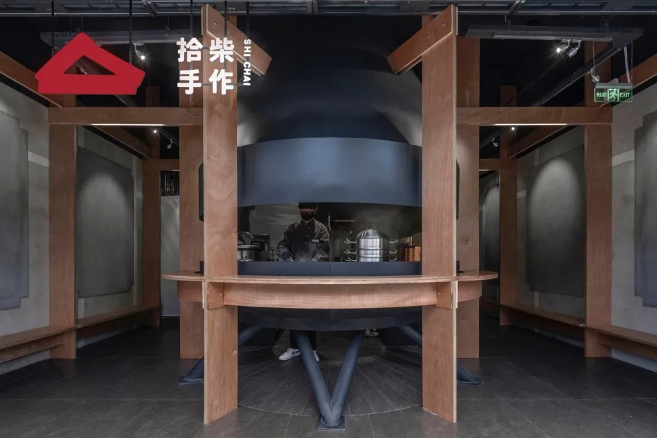 繁忙的商用廚房，配有大型烤箱、兩名人員及廚房設備