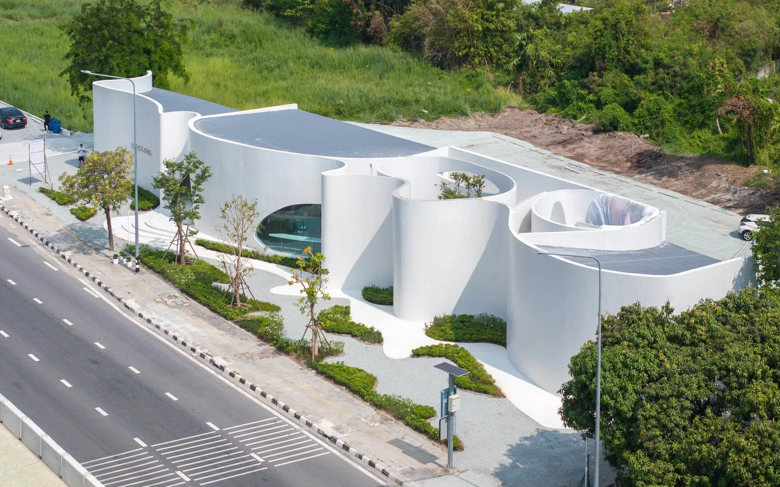 現代建築擁有大型白色客廳，周圍環繞較小房間，展現乾淨線條與極簡元素