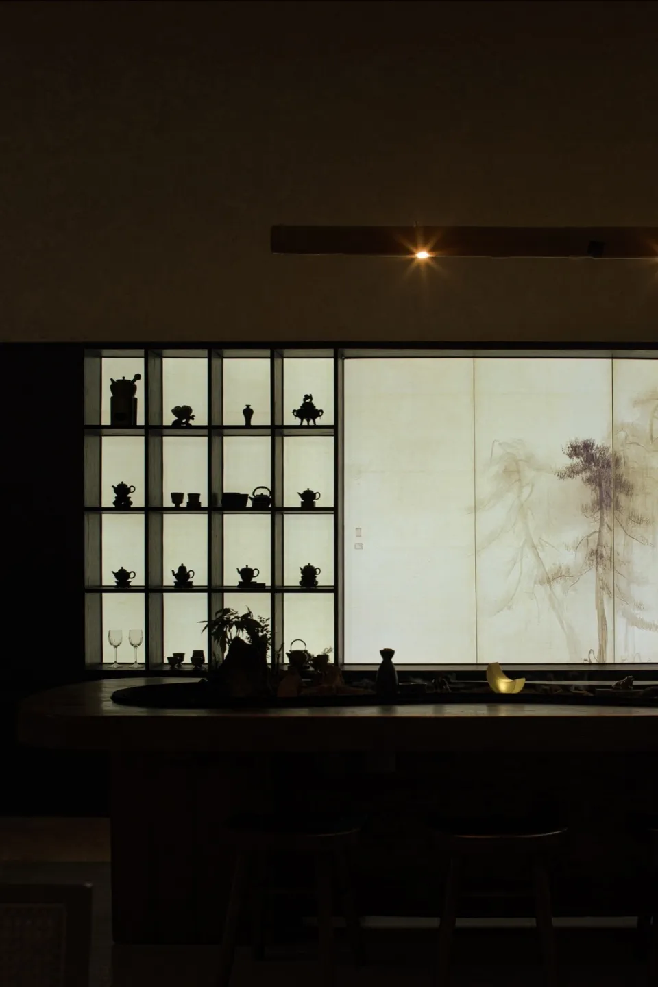 Warm and inviting Asian kitchen with a wooden table, wine glasses, cups, bowls, and vases on display