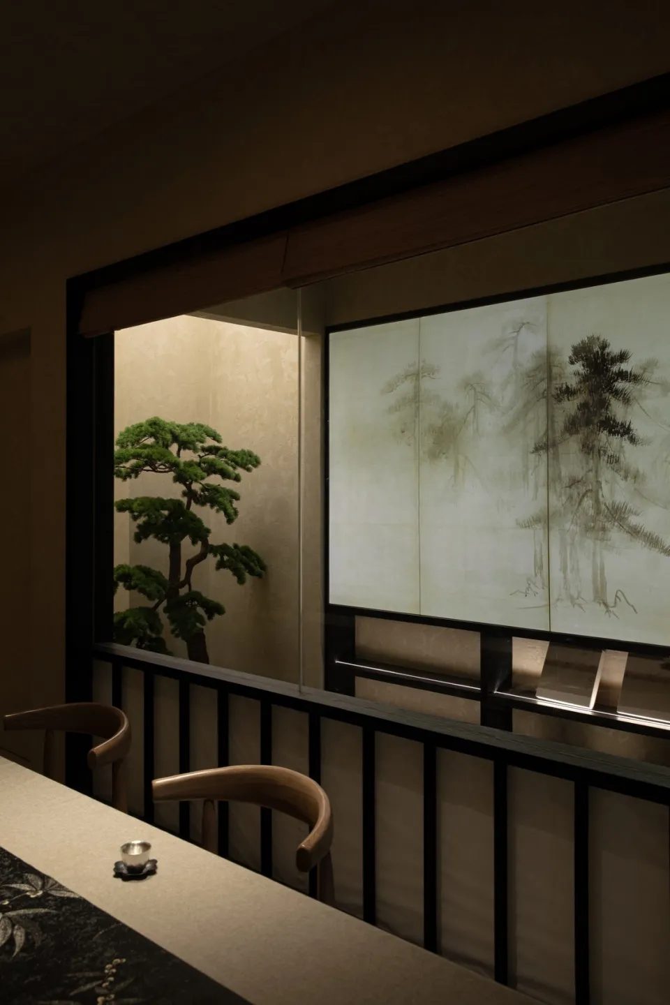 Dining area with a wooden theme, featuring a table and chairs, a potted plant, and a cozy atmosphere