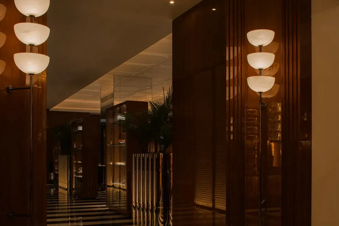 Sophisticated hallway with wooden walls and floors, featuring two potted plants and a luxurious atmosphere