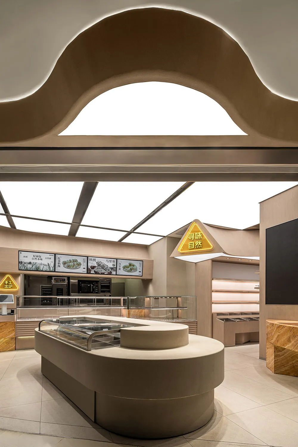 Inviting restaurant interior with wood paneling, dining tables, chairs, and glass cases displaying food items
