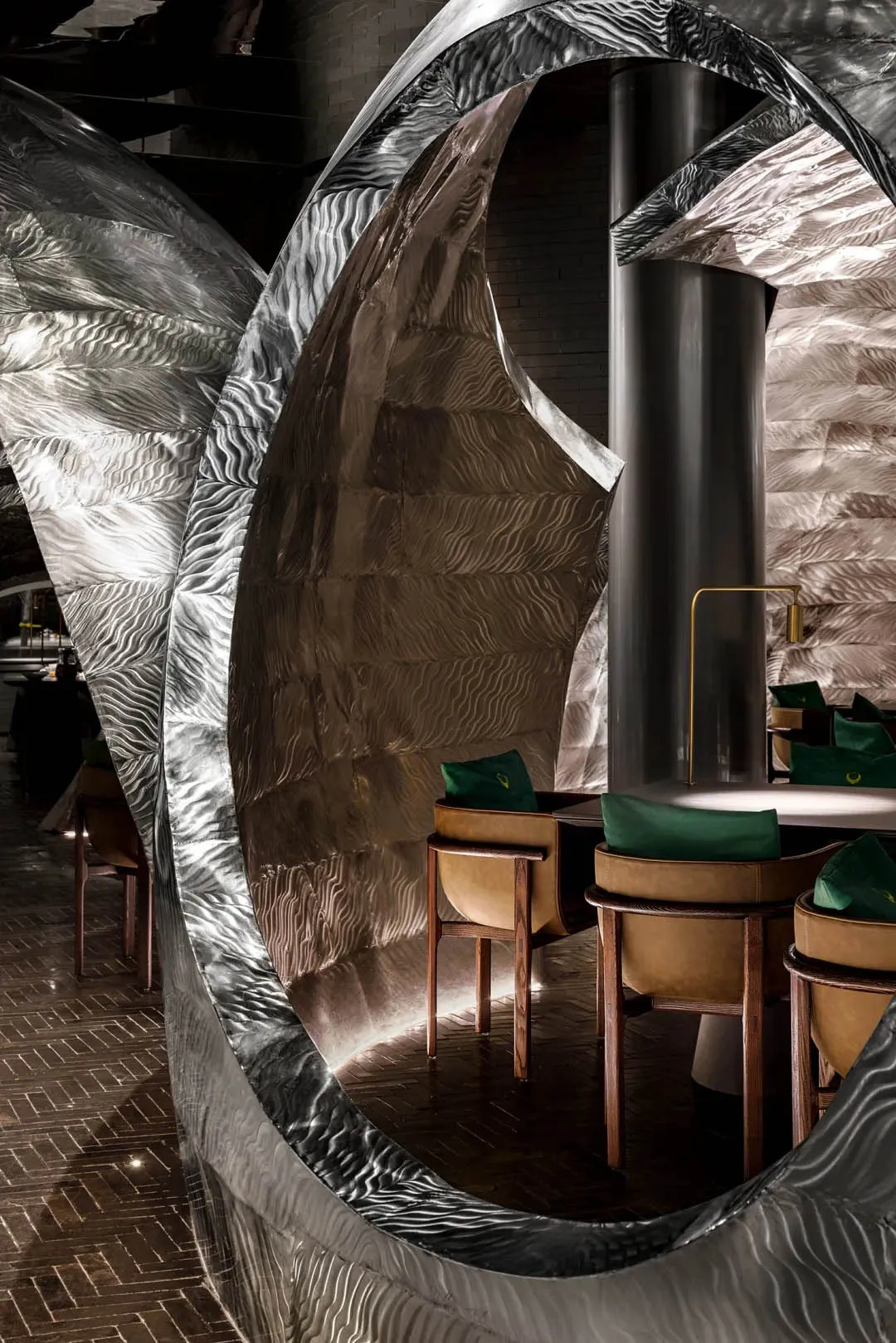 Elegant dining space with multiple tables, chairs, and metallic walls, warm lighting, and inviting atmosphere