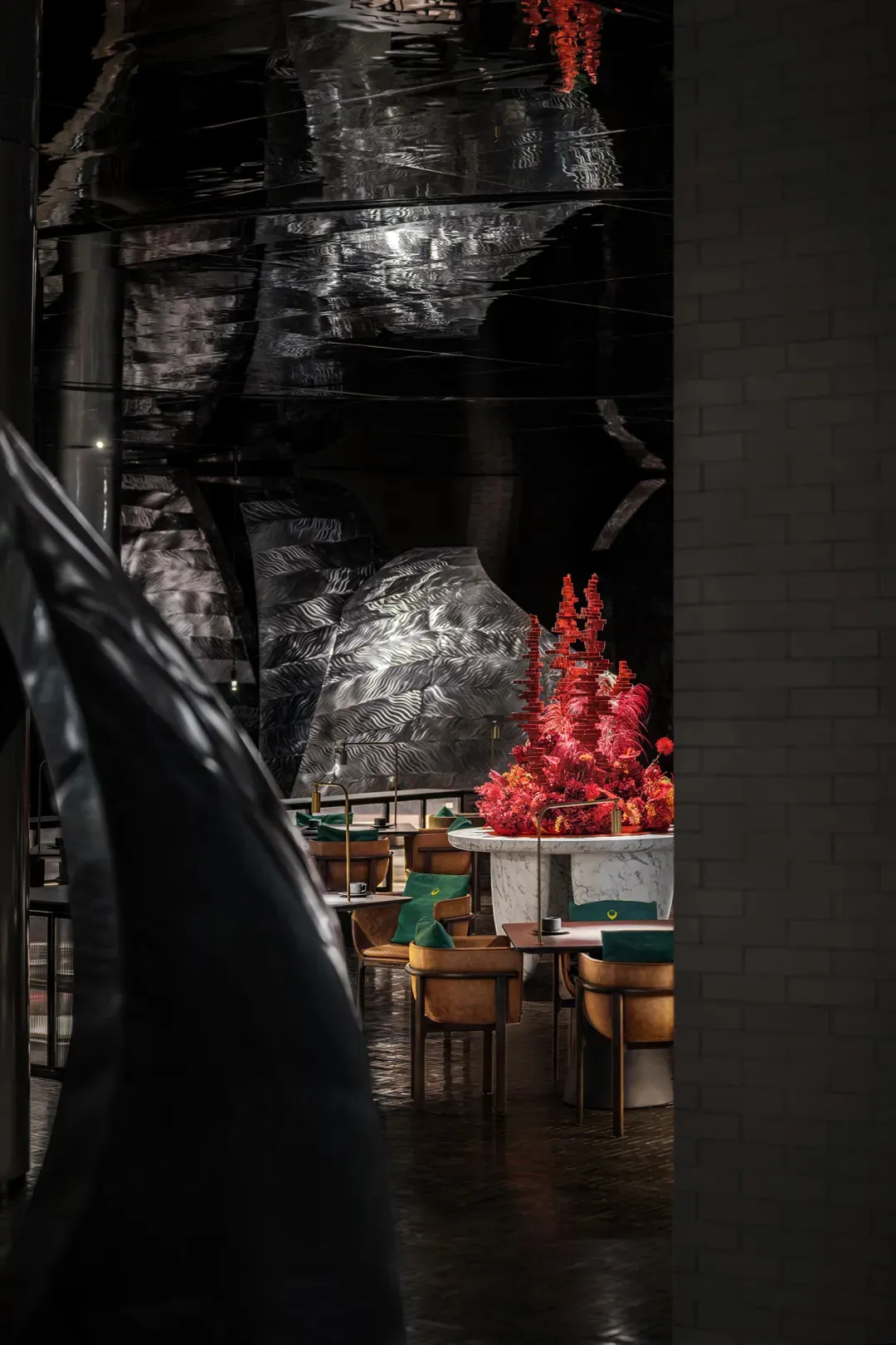 A modern restaurant dining area with multiple chairs and tables, featuring a metallic finish on the walls and a stylish atmosphere with black and red elements