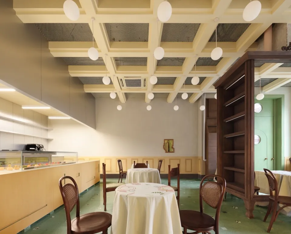 A dining area with a large table and chairs, a white tablecloth, and a cozy atmosphere