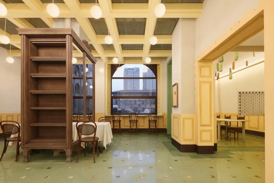 溫暖親切的餐廳用餐區，以黃色調為主、自然光線充足，配有多張桌椅