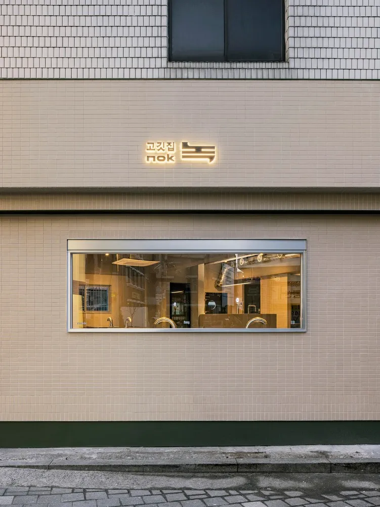 A modern Asian restaurant with a brick exterior, large windows, and comfortable seating areas