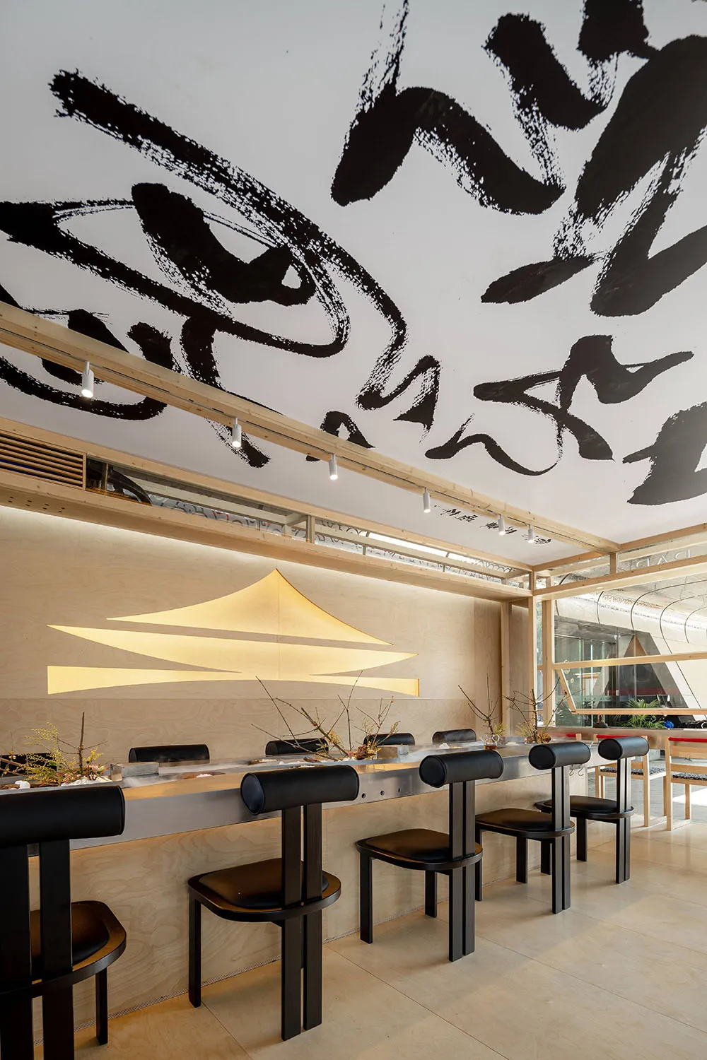 A modern restaurant interior with wooden tables and chairs, creating a warm and inviting atmosphere with numerous dining tables and chairs