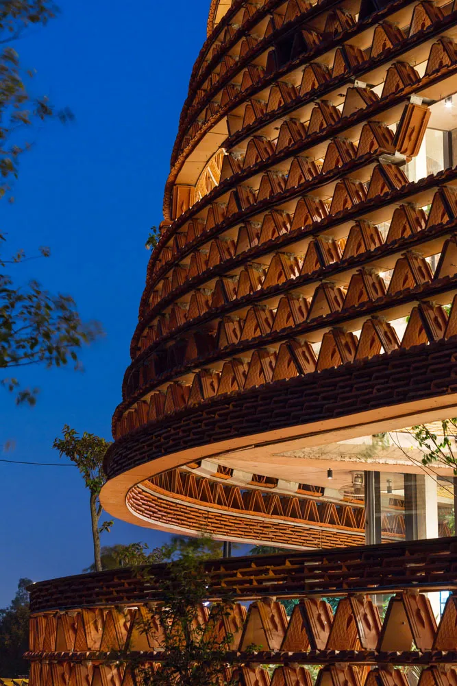 A photo of a building with a wooden exterior, featuring many windows arranged in various patterns across the facade, creating a visually interesting design