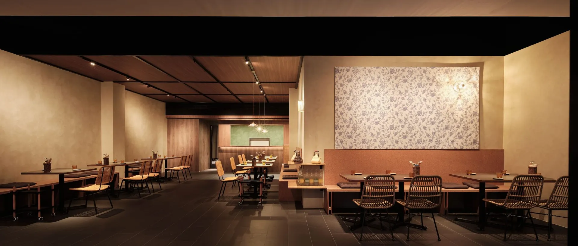 Empty restaurant with wooden floors and tables, featuring chairs placed around the dining area in a calm and inviting atmosphere