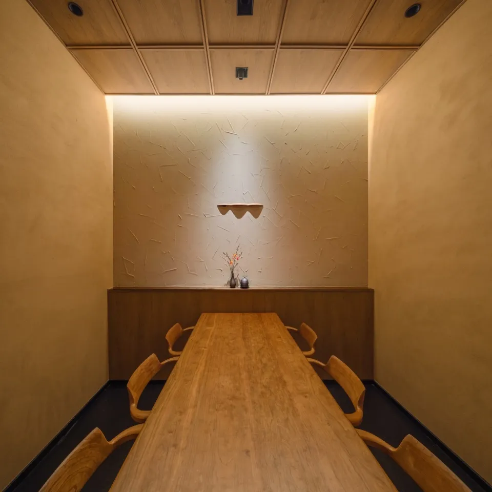 A dining area with a wooden table and six chairs, set in a clean and organized space
