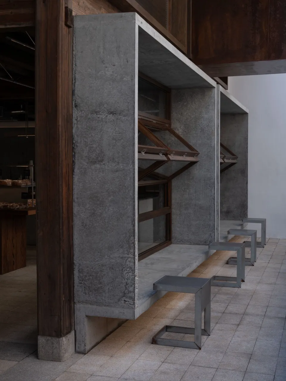 Industrial storage space with a concrete wall, a wooden door, and benches along the wall