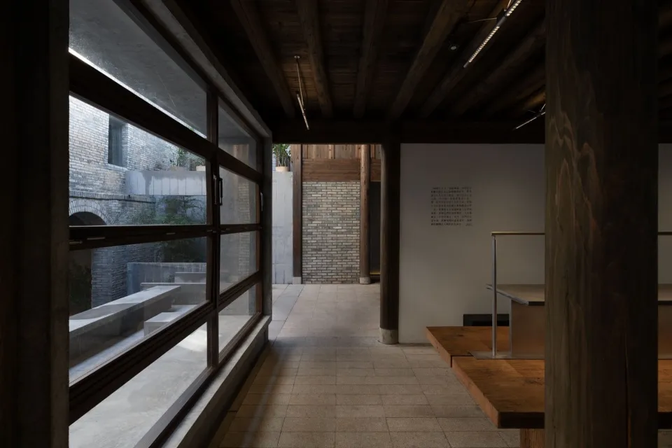 Modern restaurant interior with wooden floors and walls, large windows, and natural light