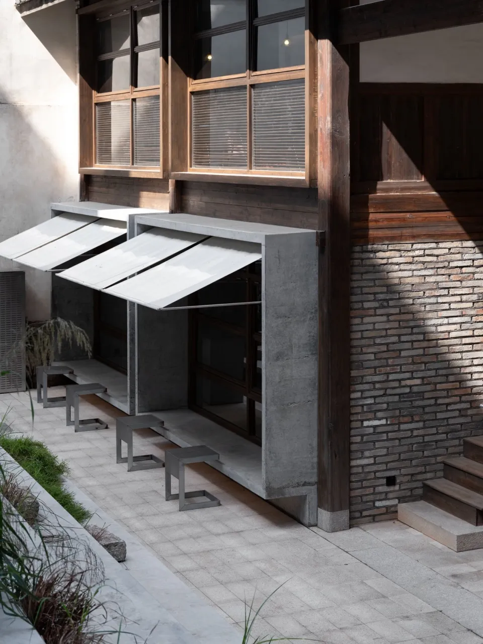 A brick building with a patio area featuring benches and dining tables, creating an inviting atmosphere for social gatherings and relaxation