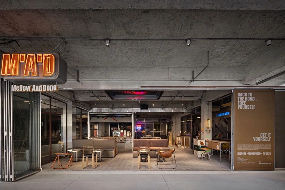 Modern interior design showroom with wooden floors and walls, metal accents, and various seating arrangements and tables