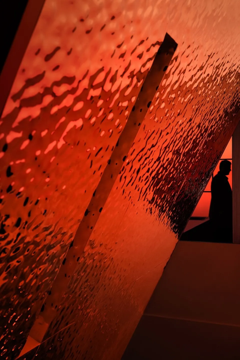 A modern interior space with orange and red glass walls, creating a striking contrast and a contemporary feel