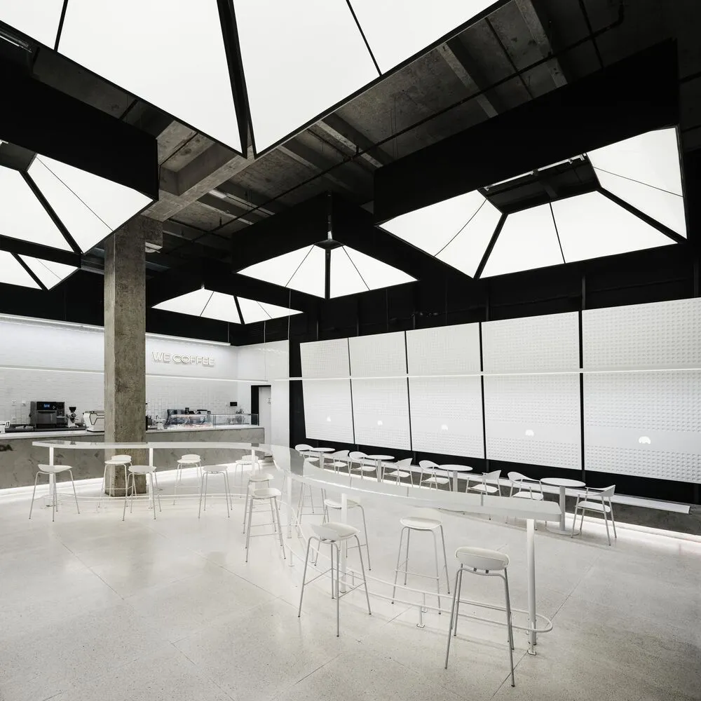 Spacious modern restaurant interior with multiple dining tables, chairs, and high ceilings