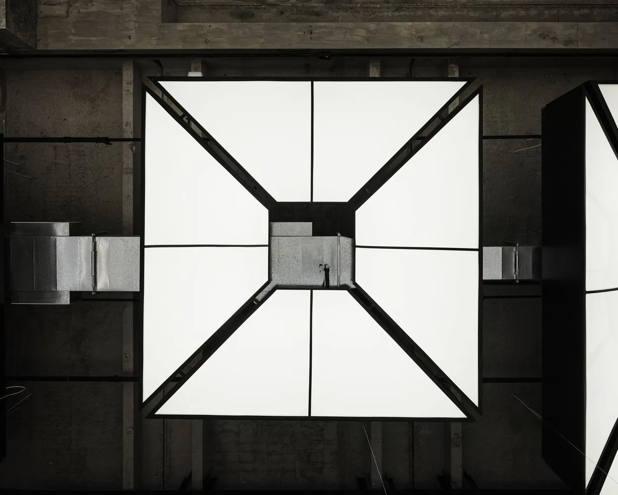 A modern interior space with a large white square structure featuring a glass-like appearance, set against a neutral background