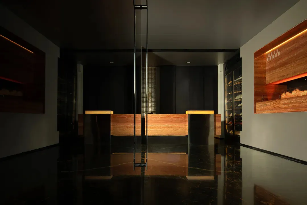 Darkened office space with a reception desk, two chairs, and a pole, featuring a modern and functional style
