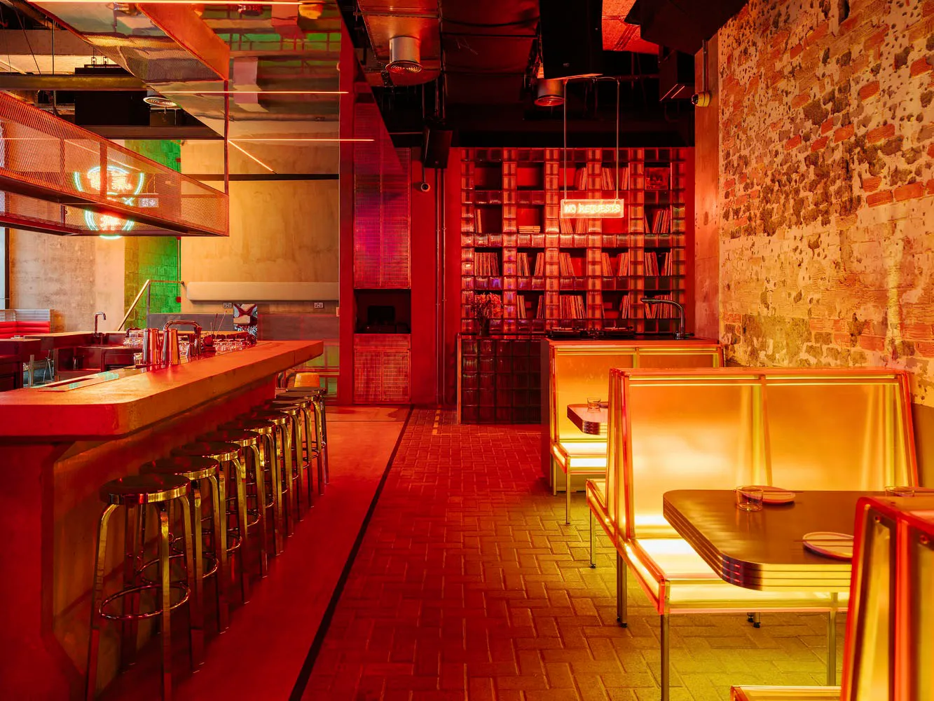 A modern restaurant interior with a long counter, stools, chairs, bookshelves, and a cozy atmosphere