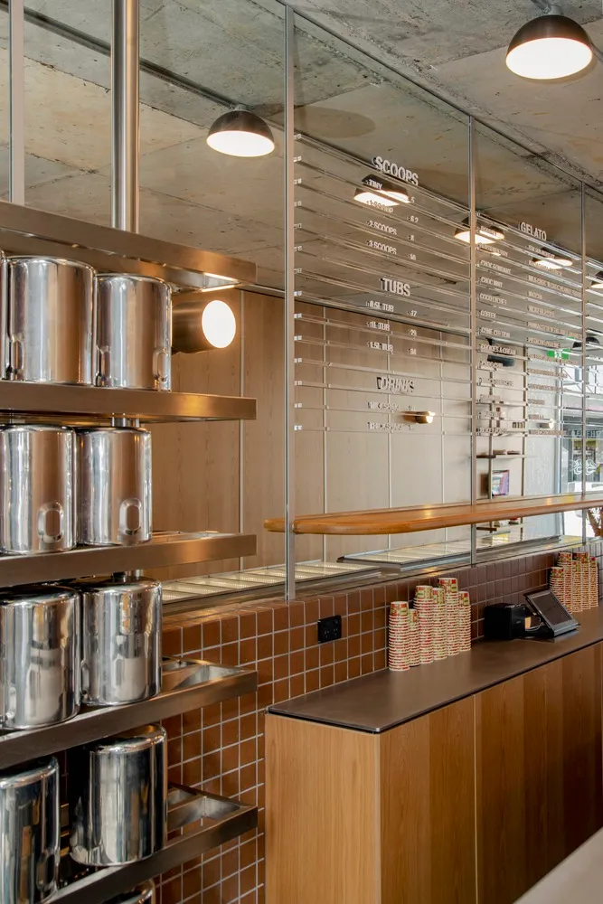 Industrial kitchen scene with a counter featuring various items, including canisters, bowls, and a cup, in a functional and organized workspace