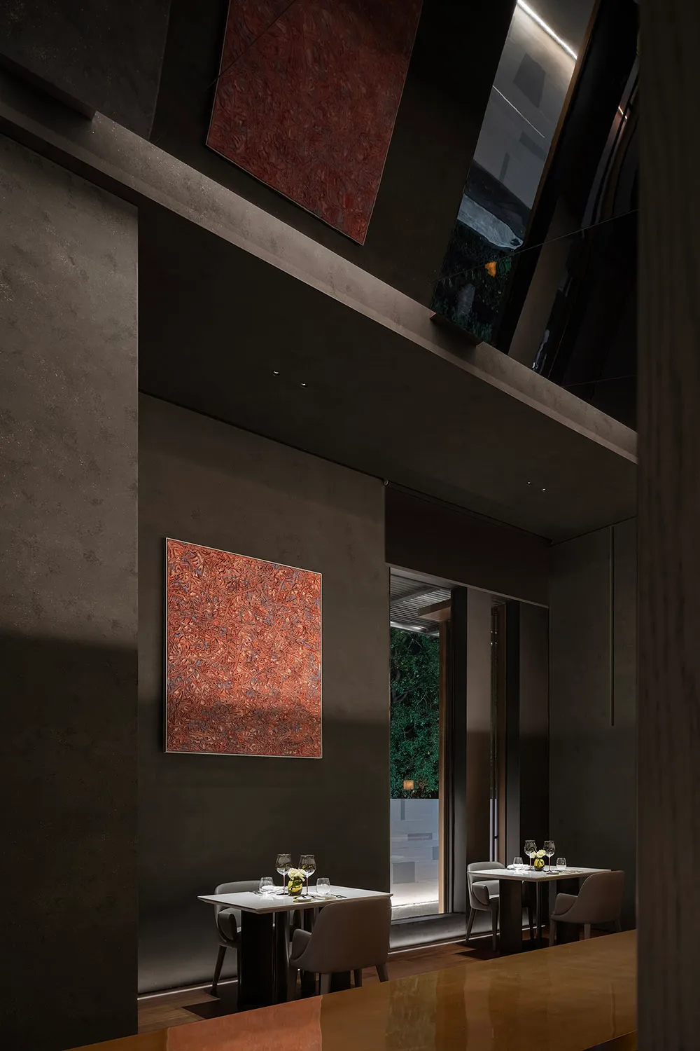 Elegant dining space with marble surfaces, tables, chairs, and wine glasses, highlighted by warm lighting