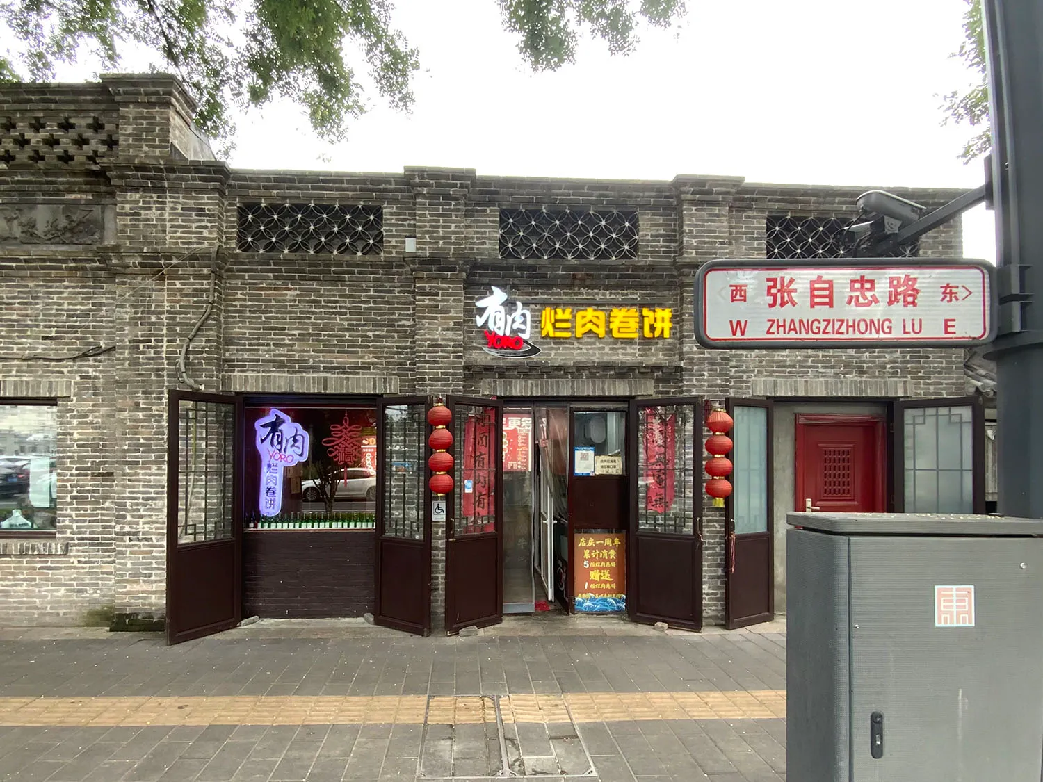 溫馨親切的亞洲餐廳，擁有磚牆外觀、木門與紅色點綴，桌椅舒適擺設營造舒適的用餐氛圍