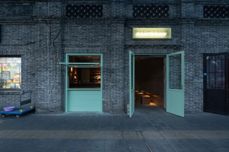 A welcoming bar area with a green door, chairs, and scattered bottles, set in a relaxed atmosphere