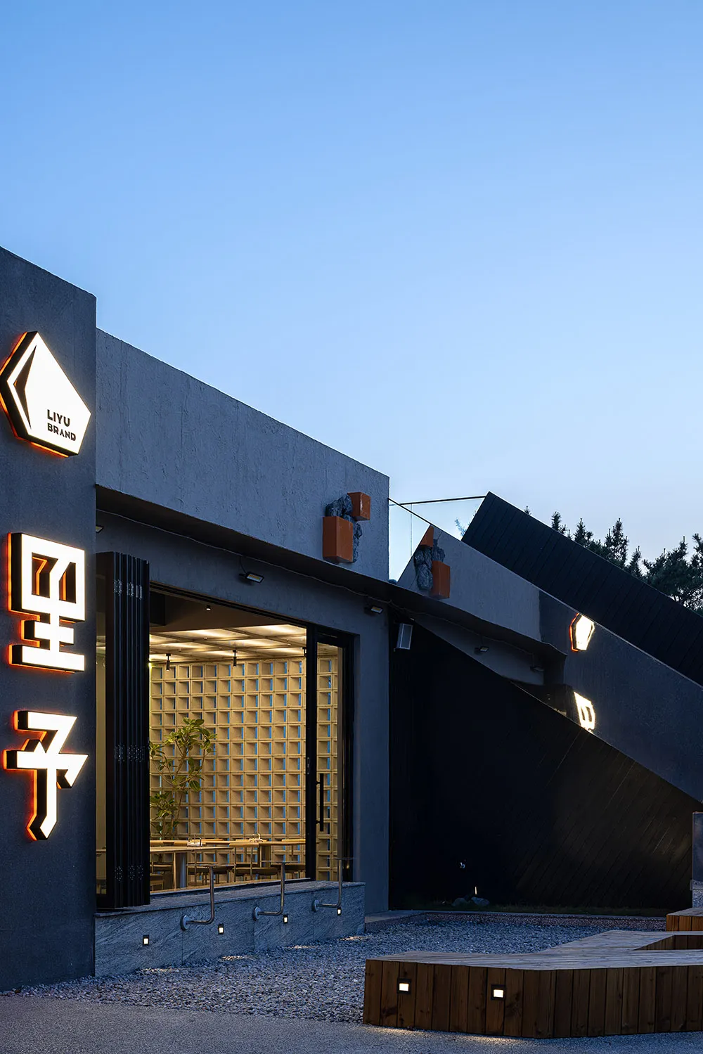 現代亞洲餐廳，擁有黑牆、自然光線與餐桌，為賓客營造舒適氛圍