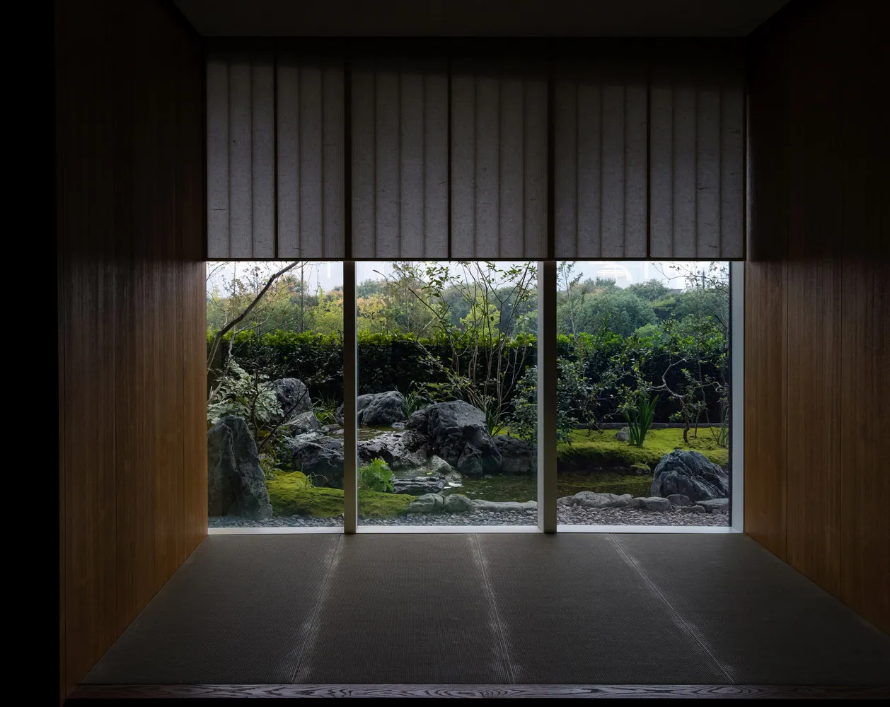A well-lit room with a tatami mat floor, two windows, and natural light