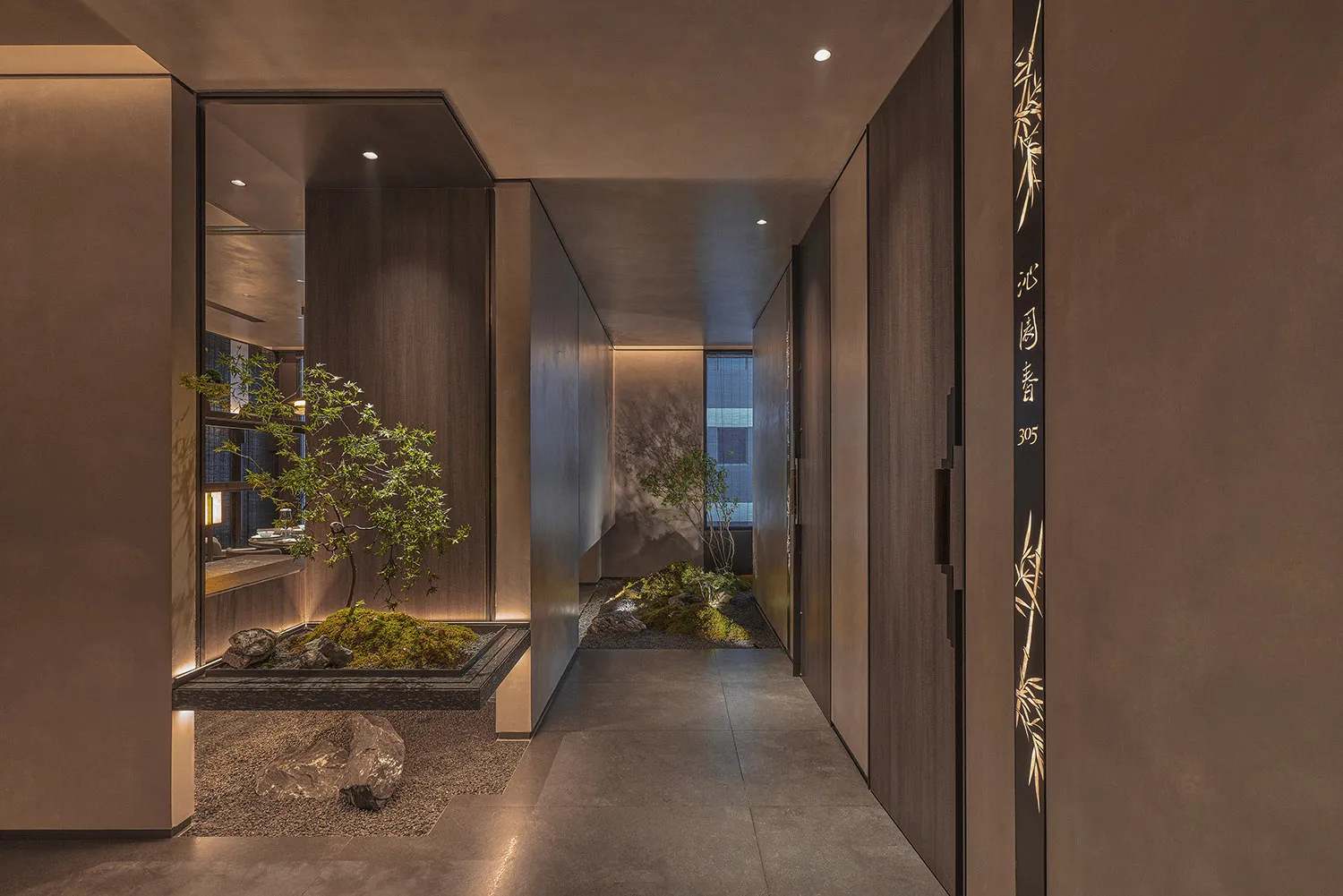 A modern hallway with two doors, one leading to a living area and the other to a dining area, flanked by three potted plants