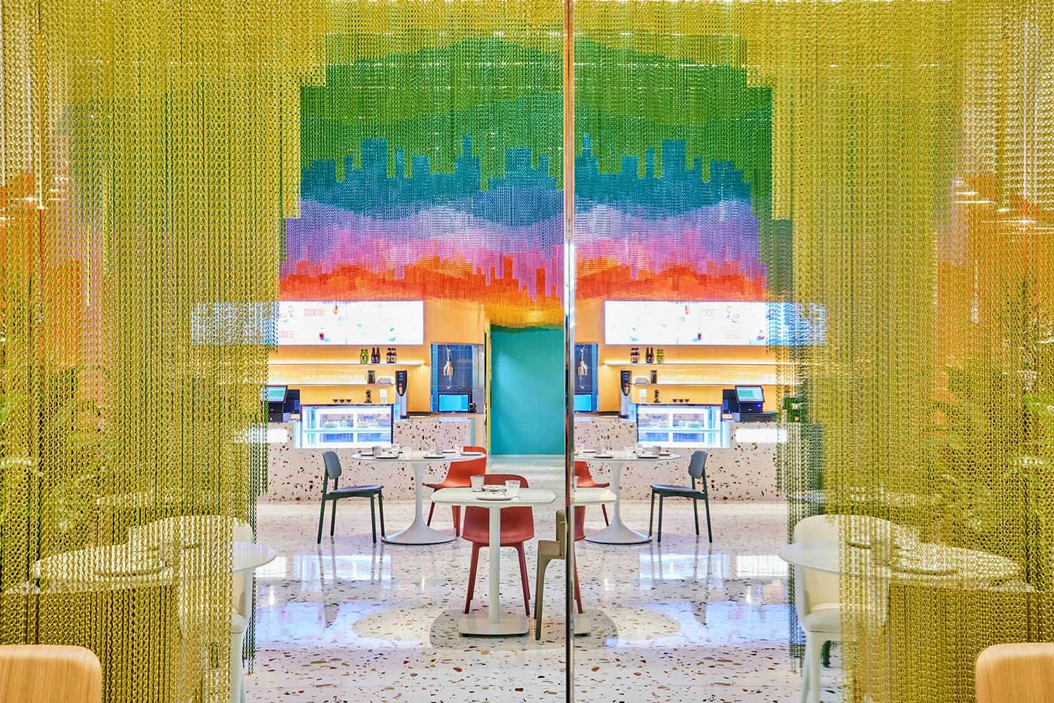 A modern dining area with multiple white tables and chairs, creating a clean and inviting atmosphere for a meal or coffee