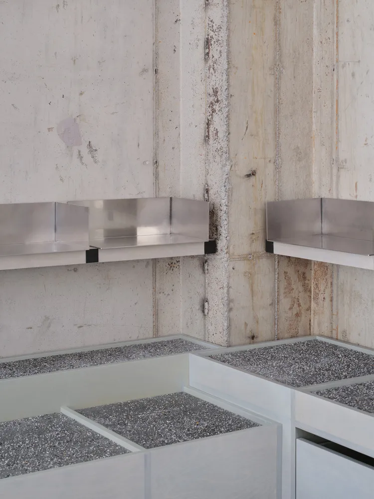 Industrial bathroom with concrete block wall, metal sinks, and minimalist design