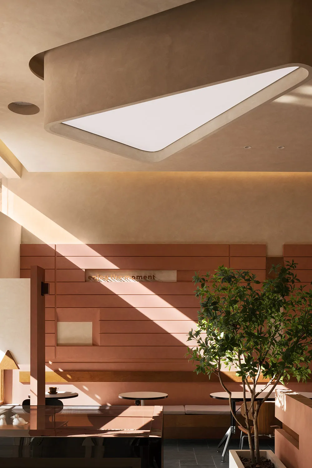 A hotel lobby with wooden walls and ceilings, featuring two potted plants and a clock on the wall, creating a warm and inviting atmosphere