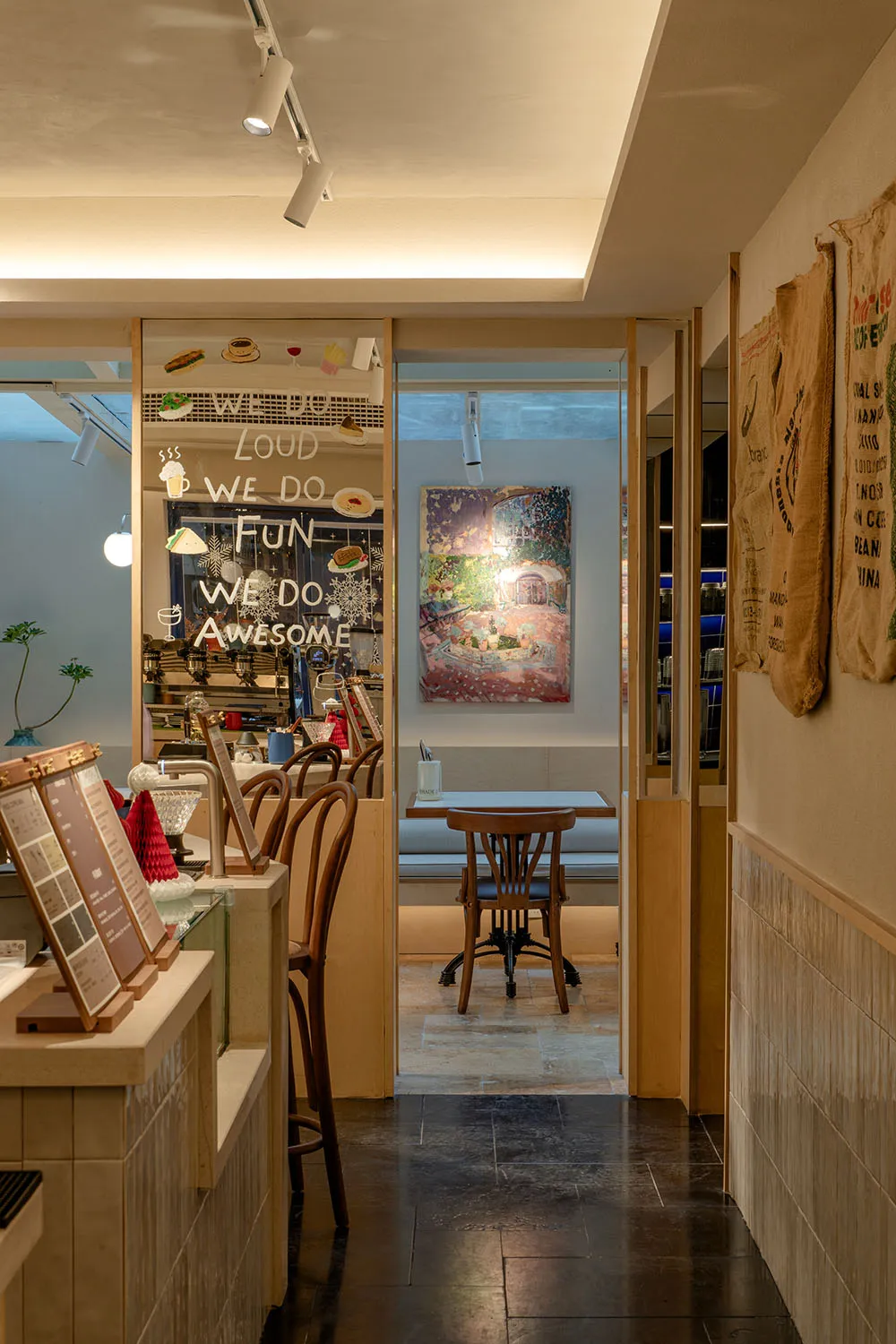 Dining area with wooden table, chairs, cups, potted plants, and vases in a warm and inviting atmosphere