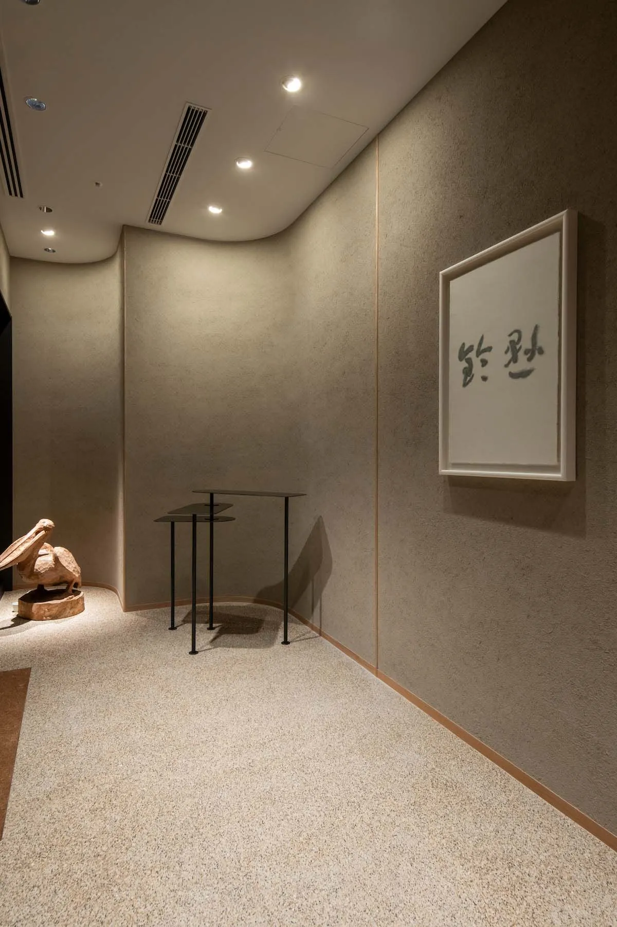 Empty room with a wooden floor, a large window, and a wall with a painting of Chinese characters, giving a calm and serene atmosphere
