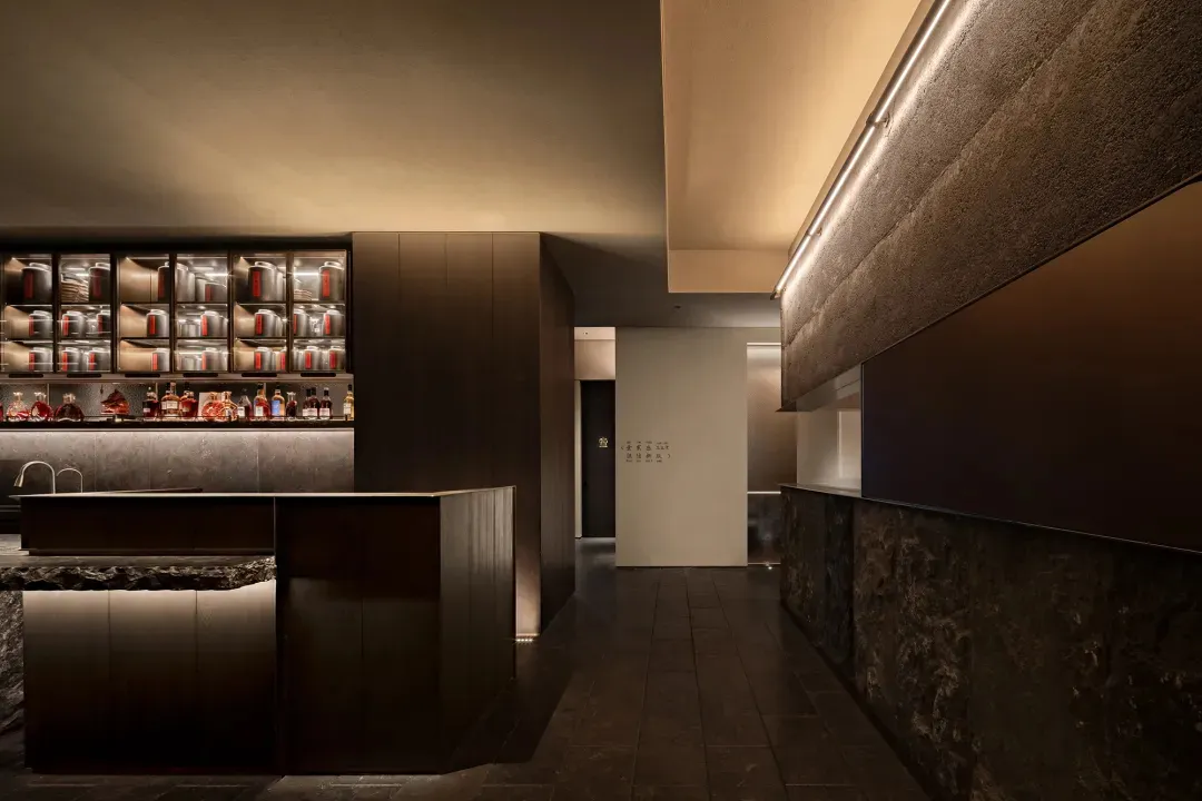 Cozy restaurant interior with wooden floors and walls, featuring bottles and a modern design