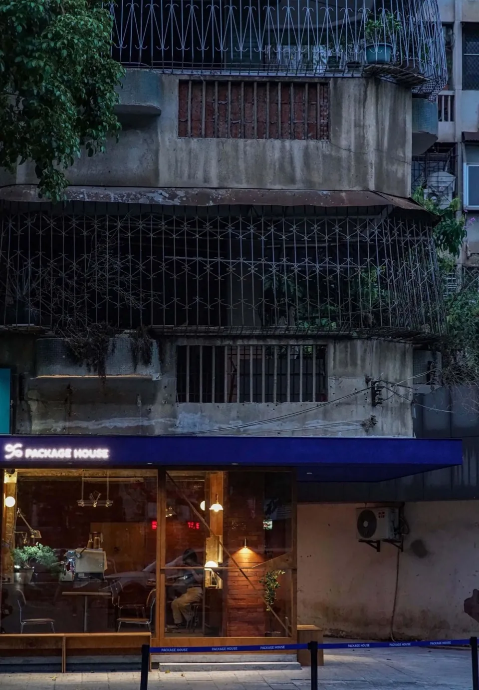 一座現代多層建築，融合混凝土、木質與金屬材質，多處窗戶帶來充足自然光線