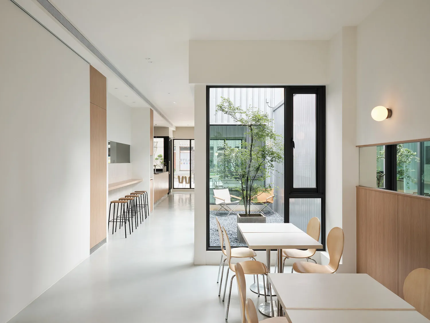 Bright and inviting restaurant interior with multiple tables, chairs, and a mix of wood and metal elements