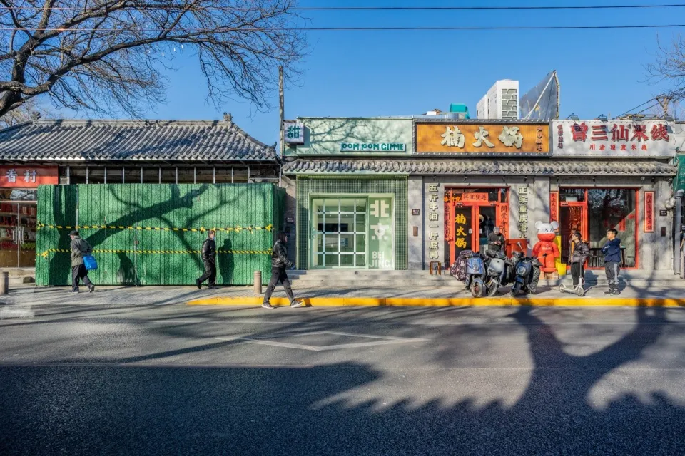 城市街角熱鬧的亞洲餐廳，紅色建築搭配綠色點綴，周圍環繞行人與機車