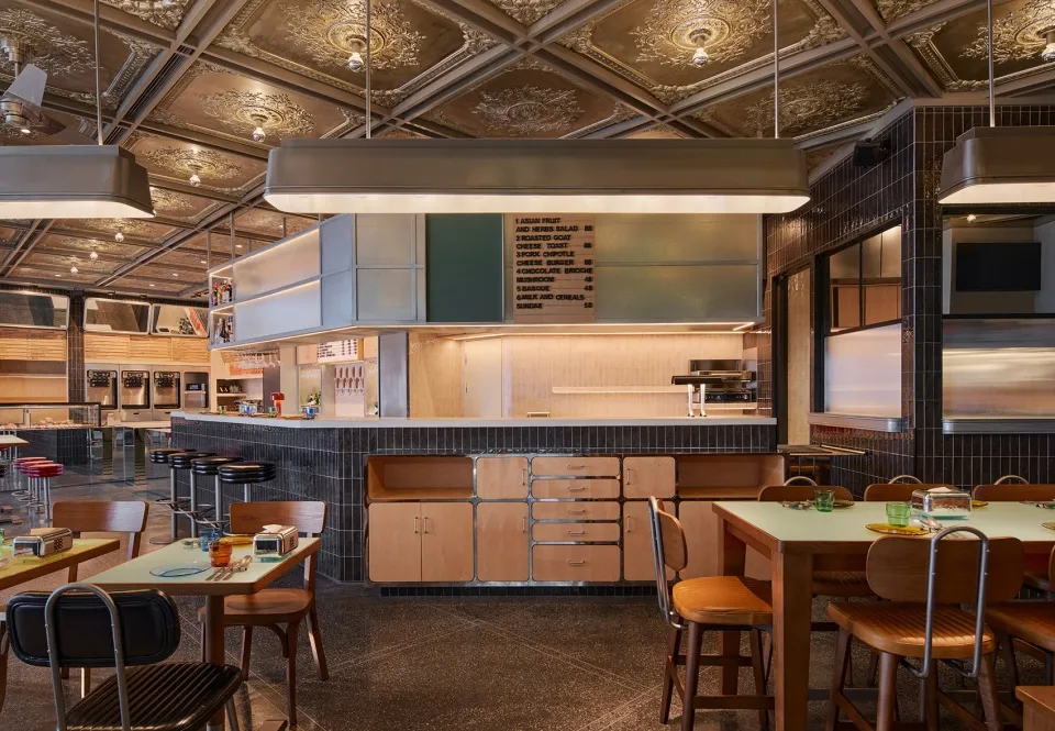 A modern restaurant dining area with a countertop, chairs, and dining tables, featuring a functional and welcoming atmosphere