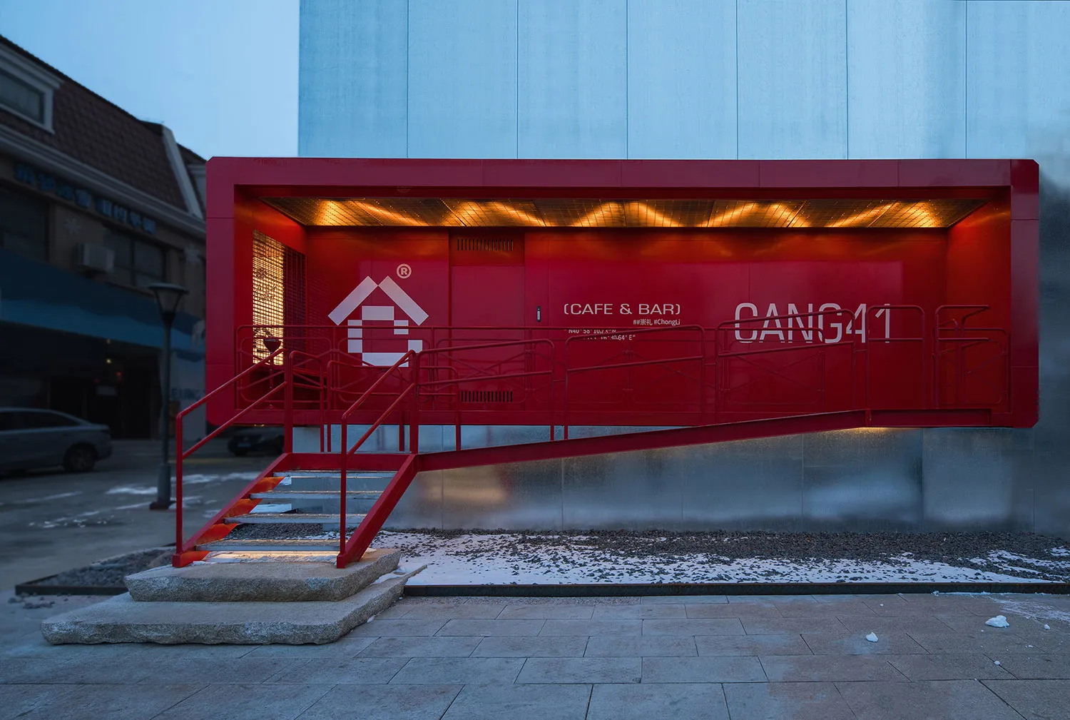 一座現代紅色外觀建築，擁有大型玻璃牆與當代設計