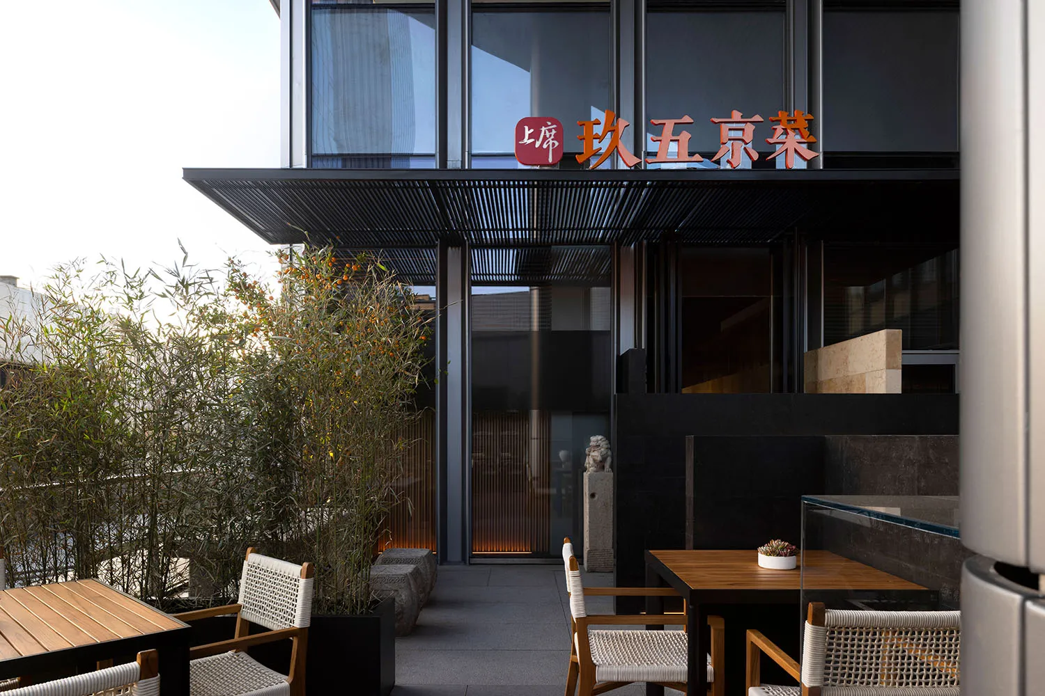 Inviting restaurant interior with tables, chairs, bar, potted plants, and Asian-inspired wall decor