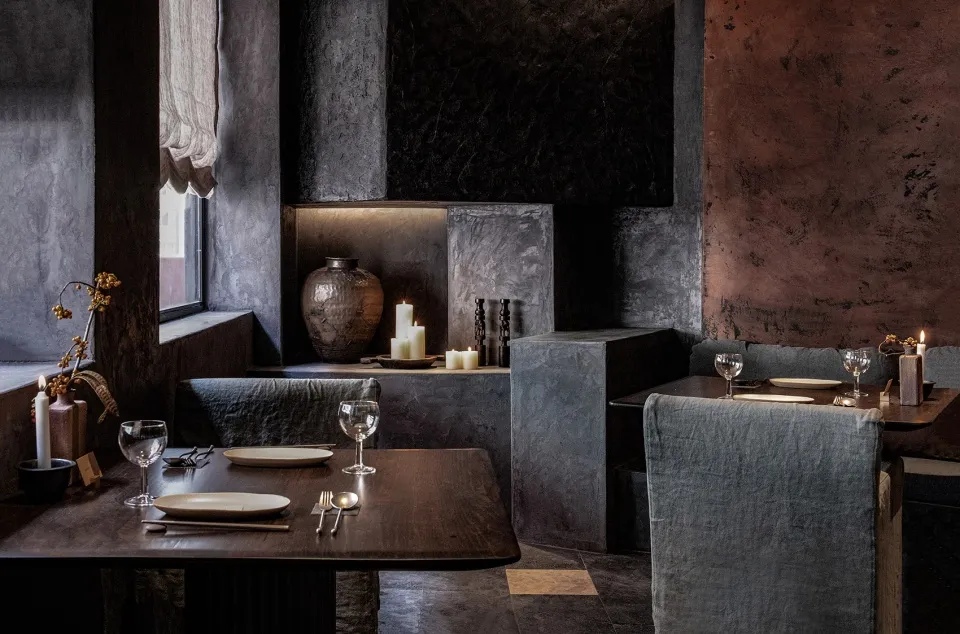 Warm and inviting restaurant interior with wooden tables, chairs, and a kitchen in the background