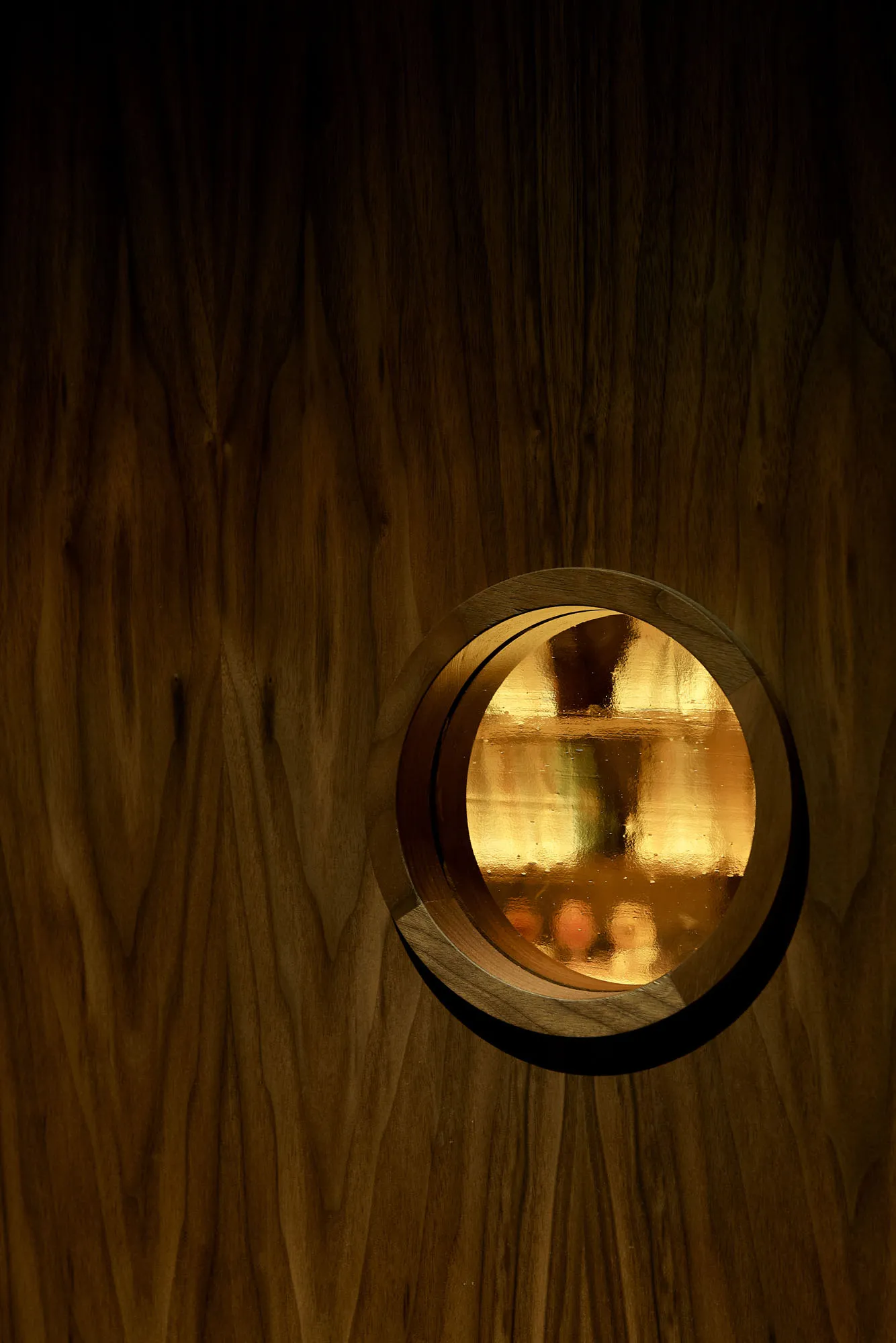 An ornate wooden doorway with a round window, creating a warm and inviting ambiance