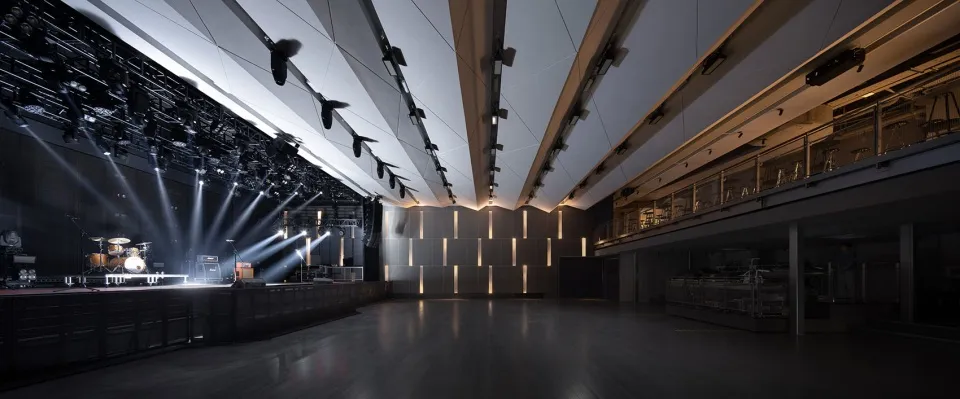 Empty auditorium with a high ceiling and white walls, giving a clean and minimalist appearance